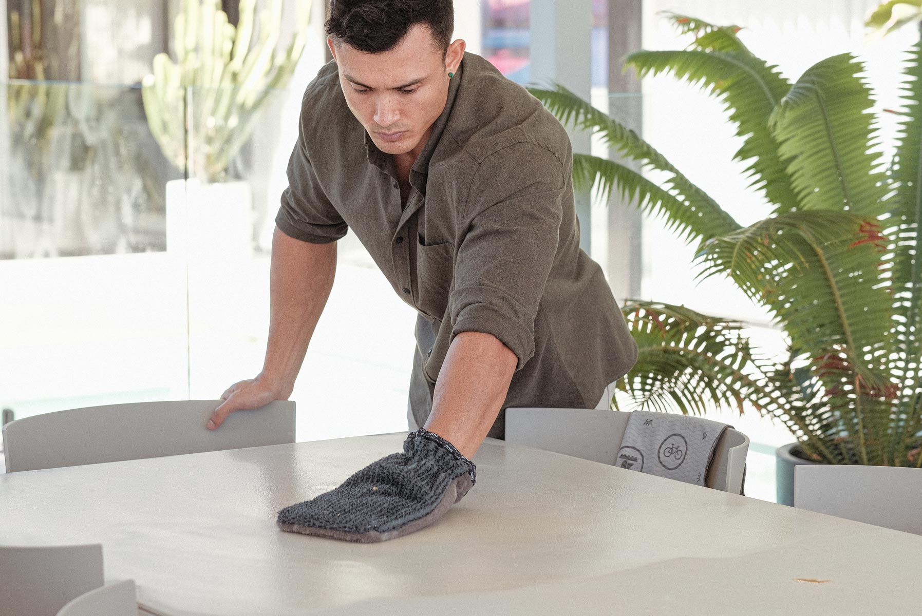 Person cleaning table outside with ENJO Outdoor Glove