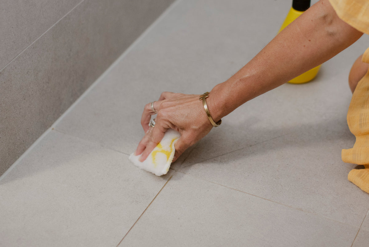 Person cleaning grout in shower with ENJO Bathroom Sponge