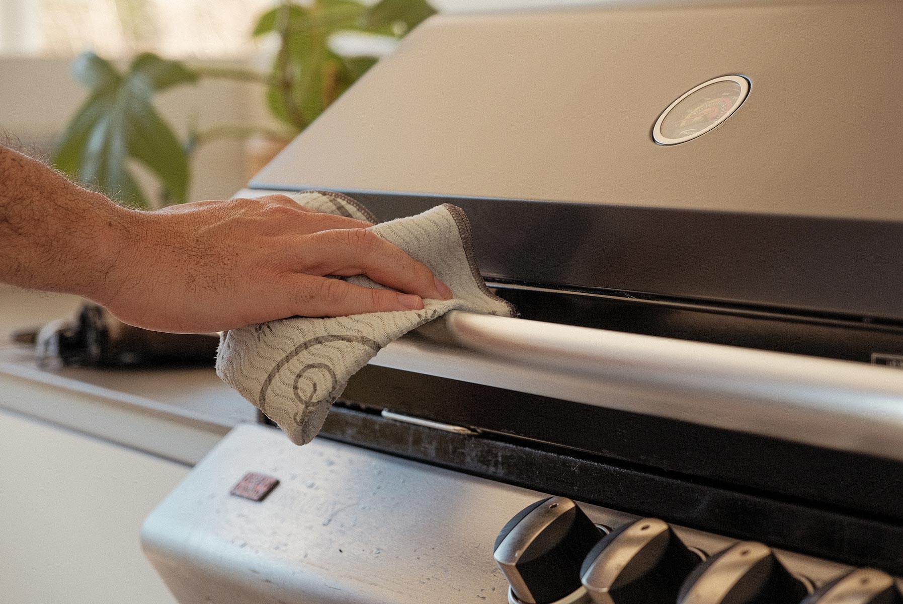 Person drying bbq outside with ENJO Outdoor Miracle