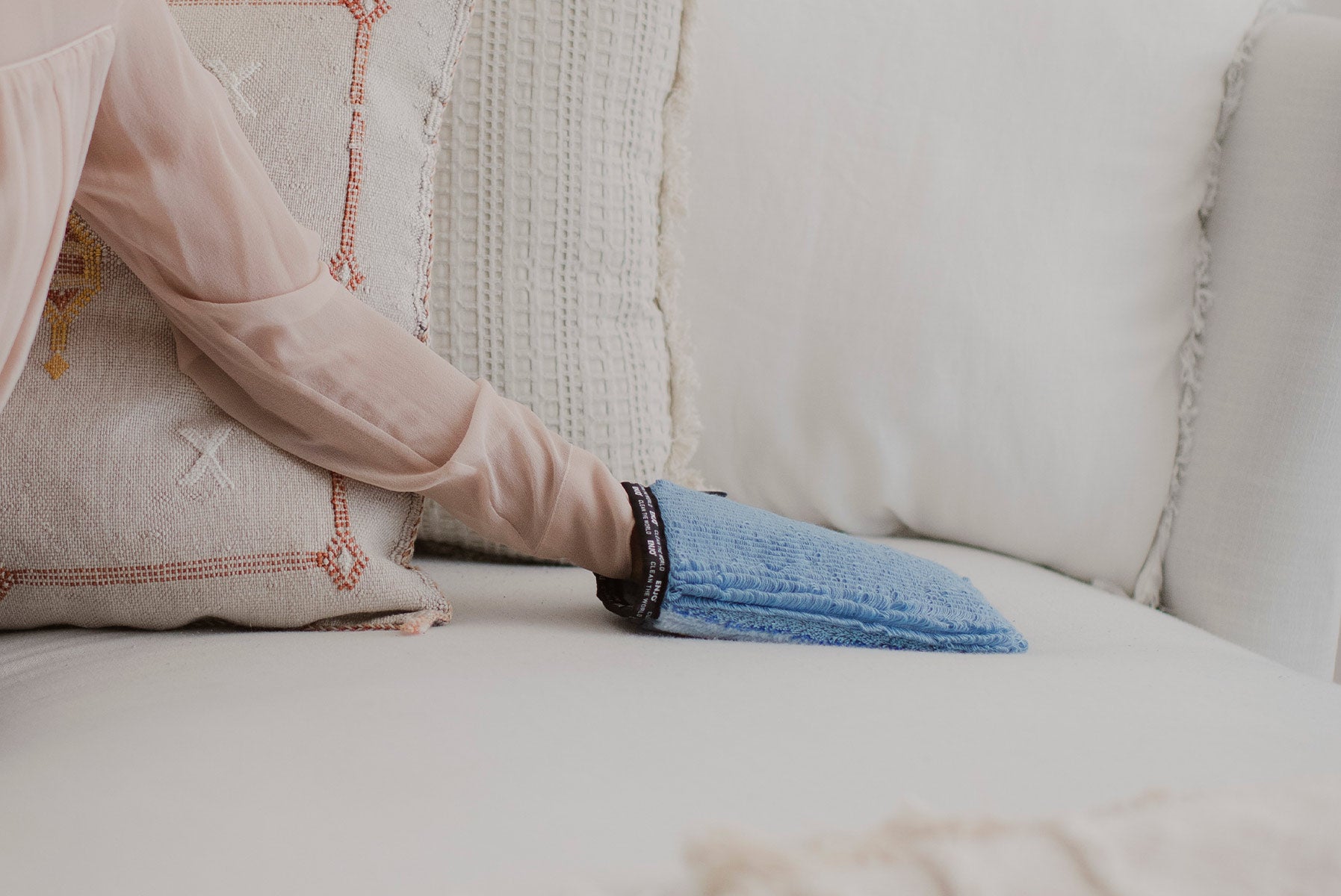Person removing marks from the couch with the ENJO Fabric Glove