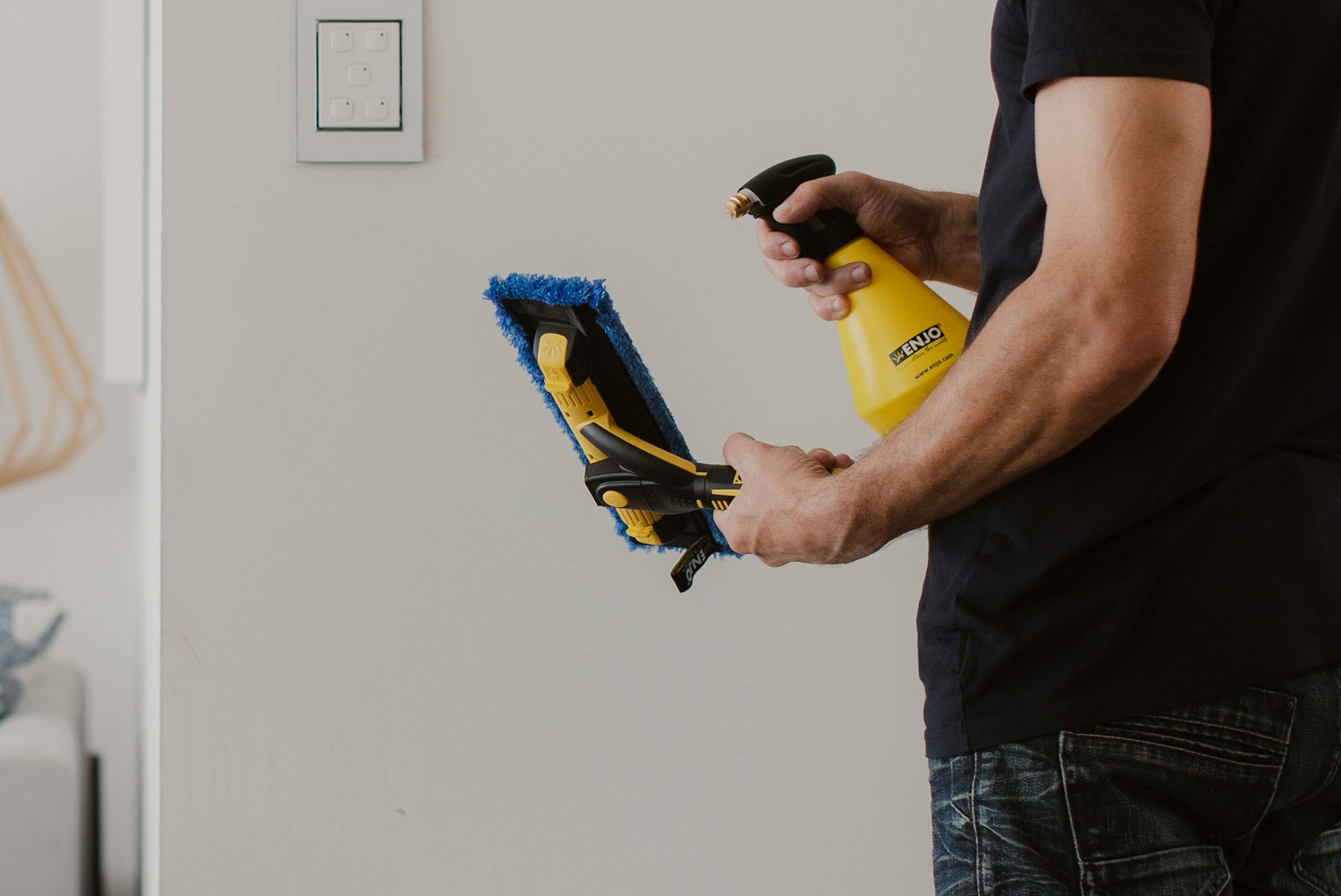 Person spraying ENJO Trigger Spray Bottle onto ENJO Window Multi Tool Fibre