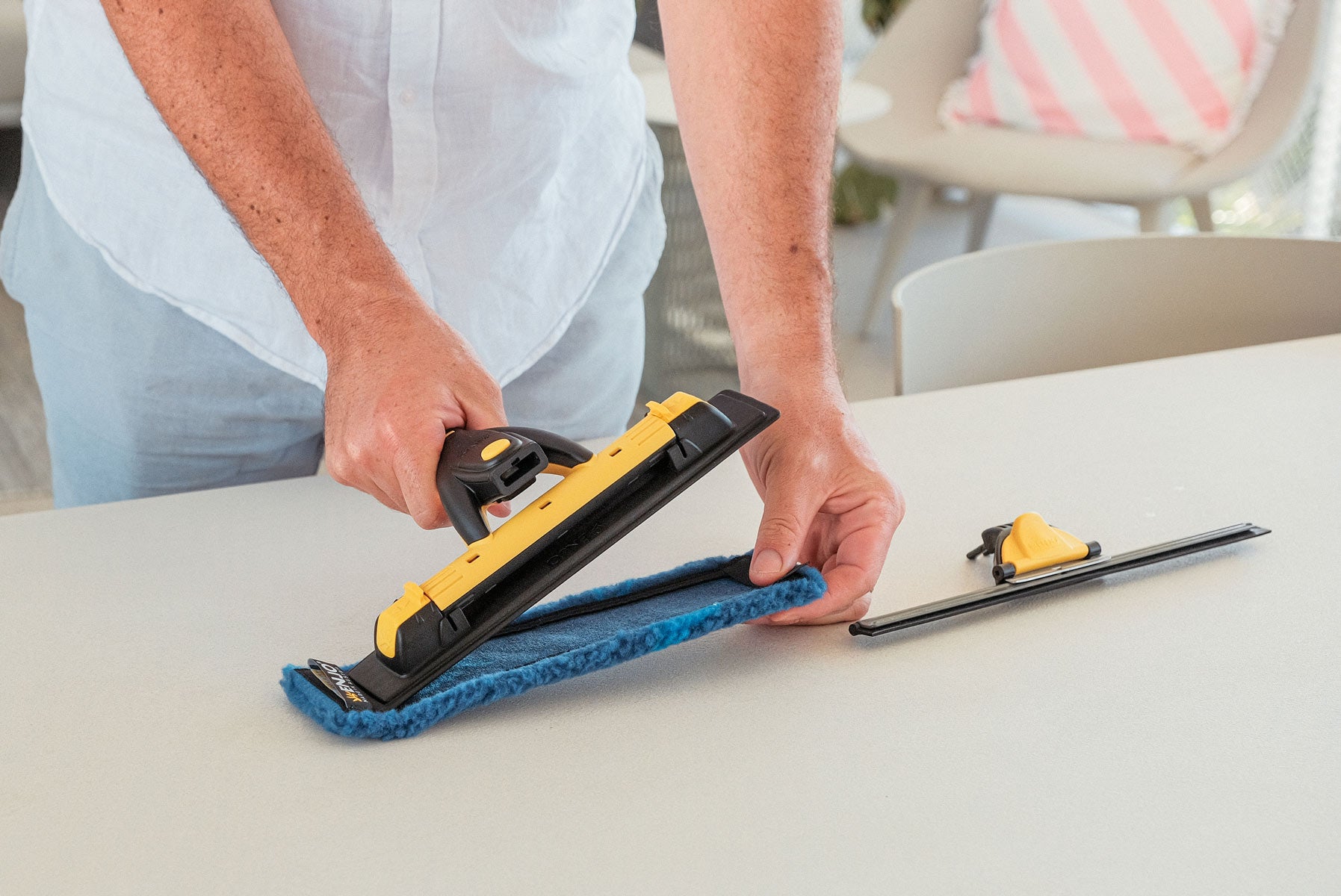 Person attaching Window Multi Tool Fibre onto Multi Tool Hardware on white table