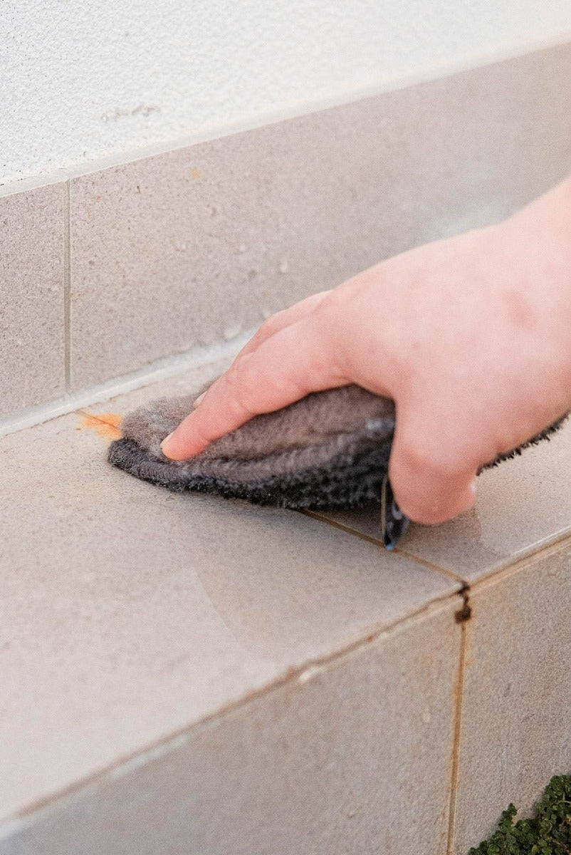 Person cleaning outdoor tiles with ENJO Outdoor Sponge