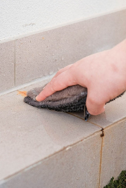 Person cleaning outdoor tiles with ENJO Outdoor Sponge