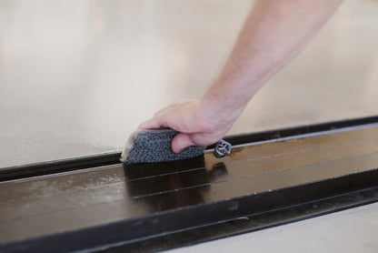 Person cleaning door tracks with ENJO Outdoor Sponge
