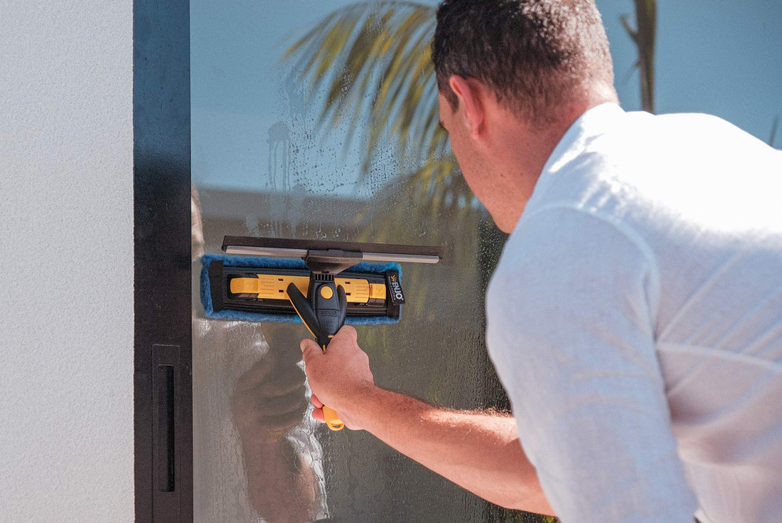 Person cleaning glass door with ENJO Window Multi Tool