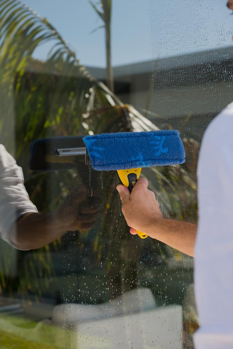 Person cleaning pool glass door with ENJO Window Multi Tool