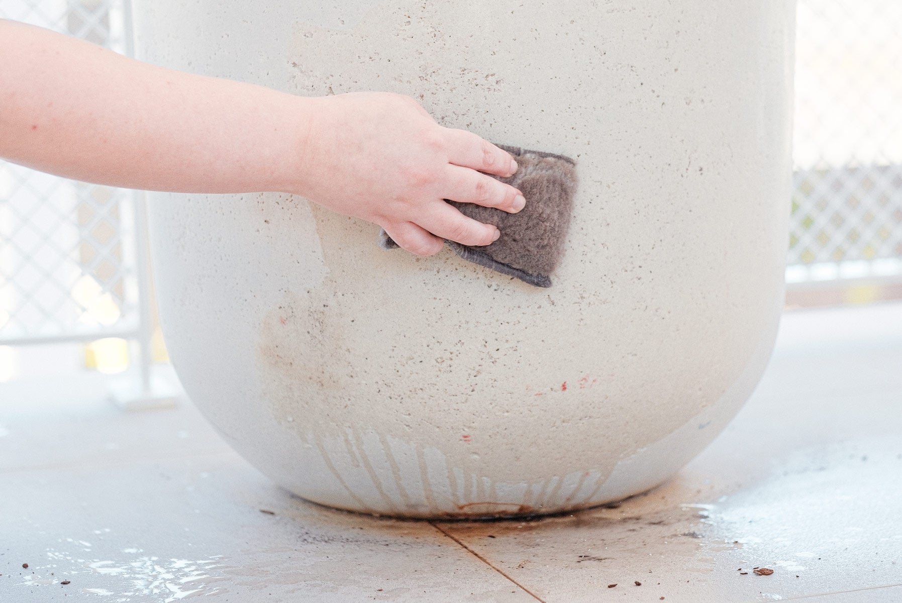 Person cleaning outdoor pot plant with ENJO Outdoor Sponge