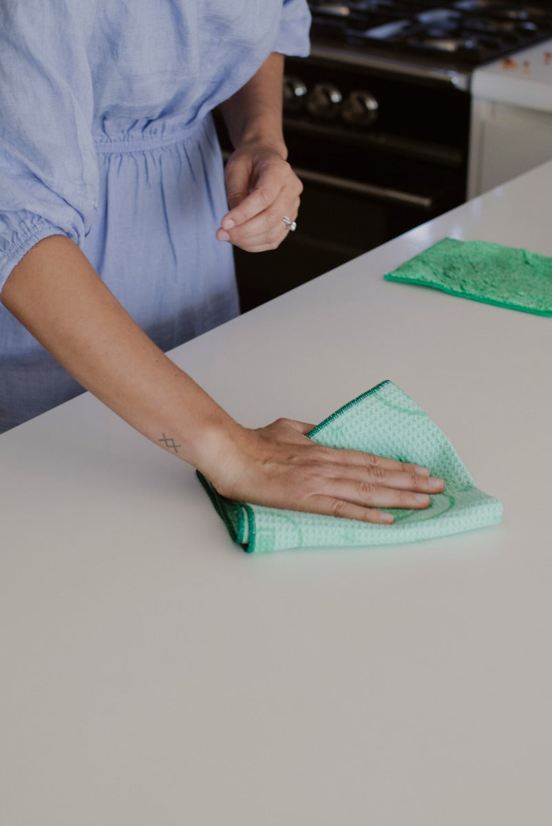 Person drying benchtop with ENJO Kitchen Miracle