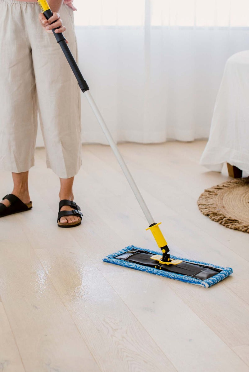 Person cleaning wooden floors with ENJO Floorcleaner and Allpurpose Floor Fibre