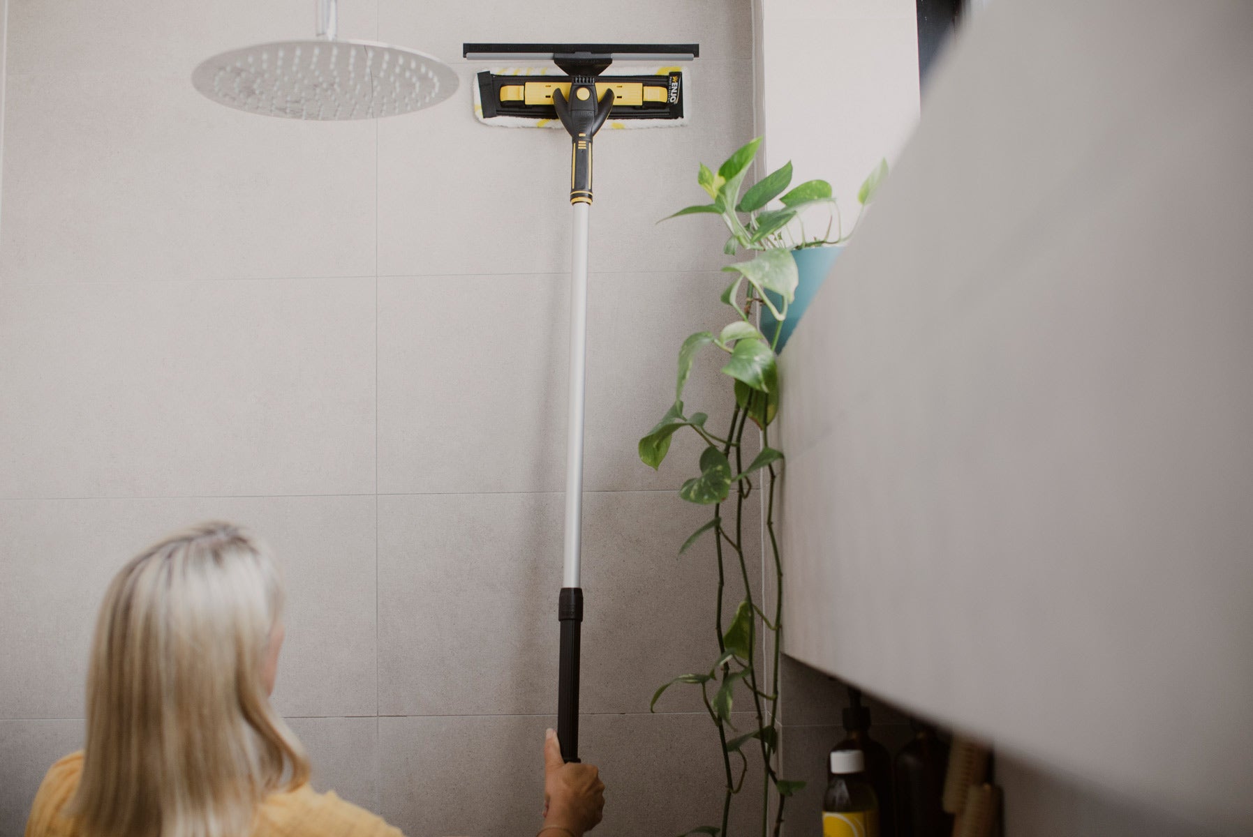 Person cleaning shower wall with ENJO Telescopic Pole