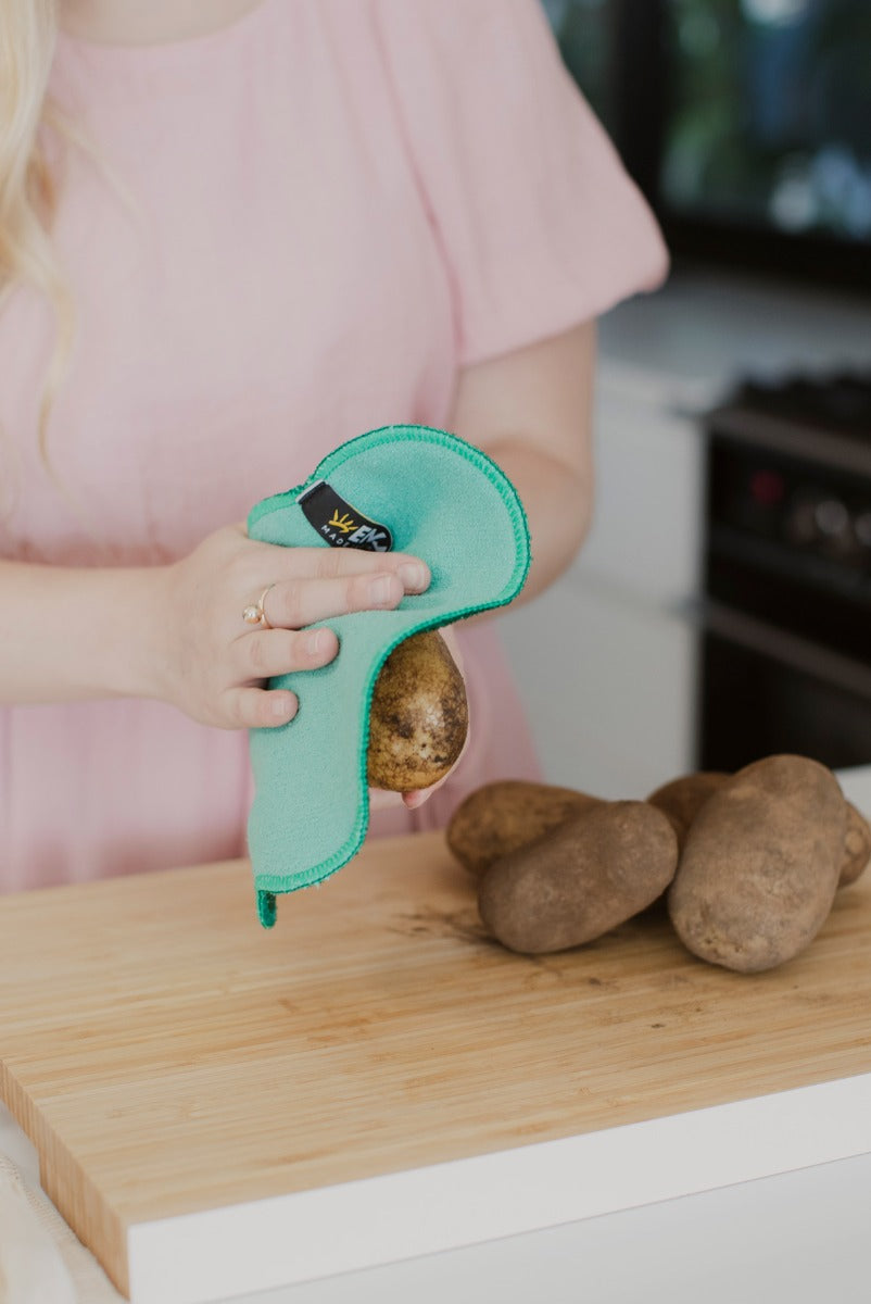 Person scrubbing dirt from the vegetable with ENJO Fruit &amp; Veg Cloth