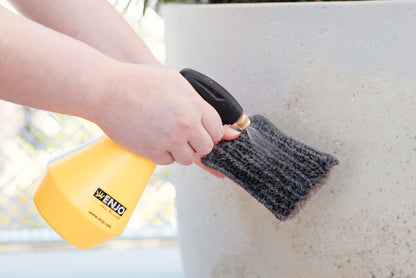 Person wetting ENJO Outdoor Sponge with water using ENJO Trigger Spray Bottle